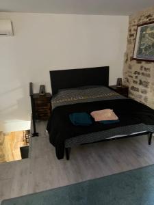 Un dormitorio con una cama con un edredón negro. en APPARTEMENT CAROMB proche Mont VENTOUX avec clim, en Caromb