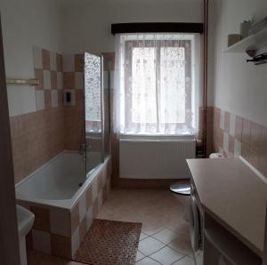 a bathroom with a tub and a toilet and a window at Holiday Home Benecko 101 in Benecko +17 photos