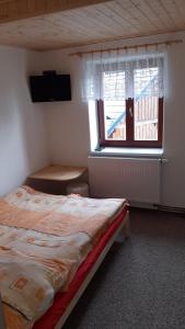 a bedroom with a bed and a television and a window at Holiday Home Benecko 101 in Benecko
