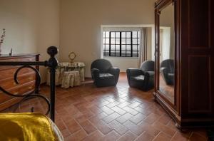 sala de estar con sillas y espejo en La casa in piazza, en Panicale