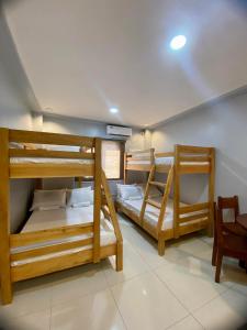 2 Etagenbetten in einem Zimmer mit einem Tisch in der Unterkunft Lakayo Hillside Apartelle in san juan la union