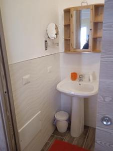 a bathroom with a sink and a toilet and a mirror at RAYO DE SOL in Marina di Casalvelino