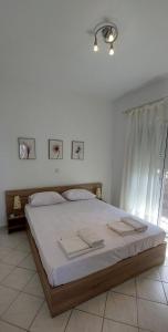 a bedroom with a large bed with white sheets at Ianos in Nea Skioni