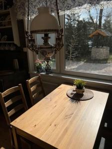 einen Holztisch im Esszimmer mit Fenster in der Unterkunft Roztocze, Podlesina; Dom z dużym ogrodem i sauną na szlaku rowerowym in Podlesina