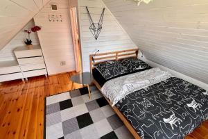 ein Schlafzimmer mit einem Bett auf einem Dachboden in der Unterkunft Roztocze, Podlesina; Dom z dużym ogrodem i sauną na szlaku rowerowym in Podlesina