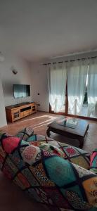 a living room with a bed and a flat screen tv at Artistika Golden Apartment in Capitana