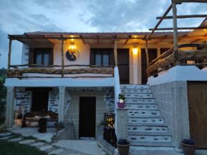 a house with a porch and stairs in front of it at Orange Garden Double Rooms in Kala Nera