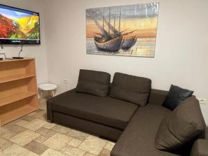 ein Wohnzimmer mit einem Sofa und einem TV in der Unterkunft ANGELO in Koper