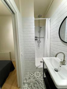 a white bathroom with a sink and a shower at Barcelona PR Guesthouse in El Prat de Llobregat