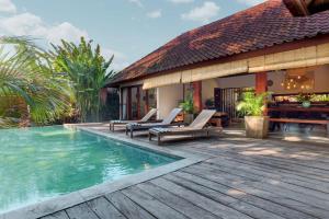 a house with a swimming pool and a wooden deck at Villa Sunari Ubud in Ubud