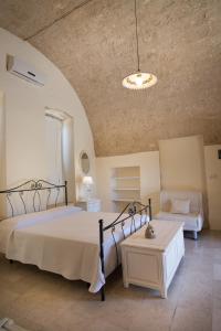 a bedroom with a large bed and a couch at Antica Masseria Ficazzana - Tenuta in Marina di Pescoluse