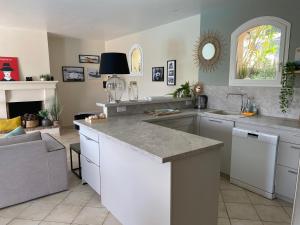 a kitchen with white cabinets and a counter top at villa claire de lune la Nartelle in Sainte-Maxime