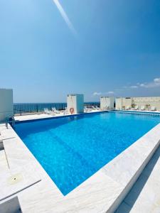a swimming pool on top of a building with the ocean in the background at Caparica Rooftop Beach Apartment in Costa da Caparica
