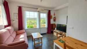 a living room with a couch and a tv at Apartamentos Corona in Comillas