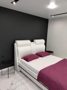 クルィヴィーイ・リーフにあるVIP апартаменты. Центр, проспект Мира 35のベッドルーム(紫のシーツを使用した白いベッド1台付)