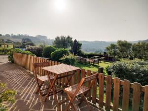a wooden table and chairs on a patio with a fence at Apartamentos Corona in Comillas