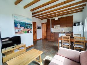 a living room with a couch and a table and a kitchen at Apartamentos Corona in Comillas