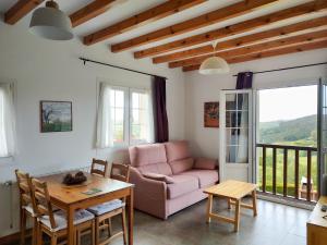 a living room with a pink couch and a table at Apartamentos Corona in Comillas