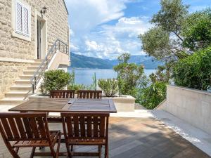 una mesa y sillas en un patio con vistas al agua en Leut Apartments, en Tivat