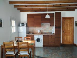 a kitchen with a table and a refrigerator and a stove at Apartamentos Corona in Comillas