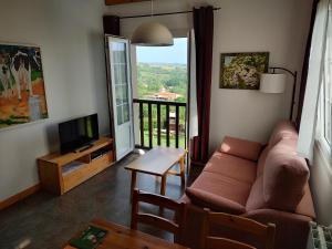 a living room with a couch and a television at Apartamentos Corona in Comillas