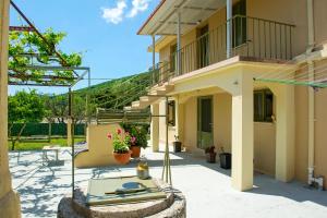 a house with a patio and a balcony with flowers at Garbis Garden View in Valsamáta