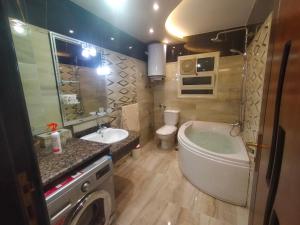 a bathroom with a tub and a toilet and a sink at شقة فندقية فيو نيلي in Cairo