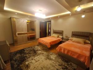 1 dormitorio con 2 camas y alfombra en شقة فندقية فيو نيلي en El Cairo