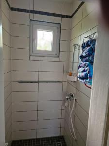 uma casa de banho com um chuveiro, uma janela e toalhas em Happy Place Indu Style em Korbach