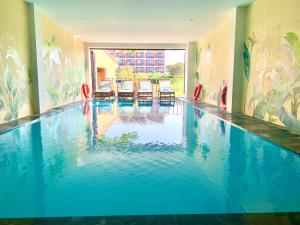 uma grande piscina com água azul num edifício em Aman Boutique Hotel em Hoi An