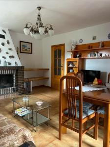 sala de estar con mesa y chimenea en Casa Pepe, en Navarredonda de Gredos