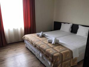 ソゾポルにあるАпартхотел Созополски перлиのベッドルーム(白いシーツを使用した大型ベッド1台付)