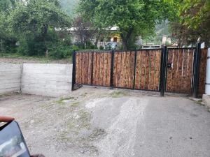 a wooden gate in a yard with a fence at Guest House Adelina in Mestia