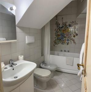 een badkamer met een wastafel, een toilet en een bad bij Il Ruscello di Casa Teresa in Positano