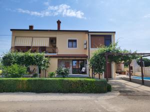 une maison avec une haie devant un bâtiment dans l'établissement Alba apartment with swimming pool, à Kanfanar