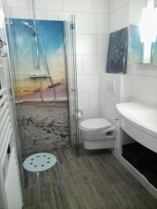 ein Bad mit einer Dusche, einem WC und einem Waschbecken in der Unterkunft Reetdach Friesenhof Süderende in Westerland