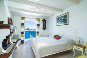 a bedroom with a white bed and a fireplace at Beach House Sveti Jakov 2 in Dubrovnik