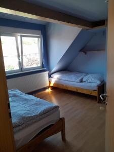 a bedroom with two beds and two windows at ZiniMiri in Freiensteinau