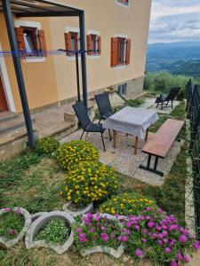 un patio con flores, mesa y sillas en GuestHouse Flora en Koper