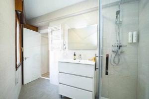 a bathroom with a white sink and a shower at Mirador Del Puerto in Lastres