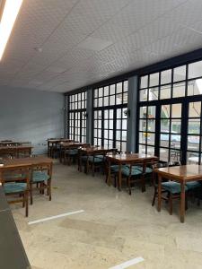 a row of tables and chairs in a room with windows at Blue Topas Otel in Burhaniye