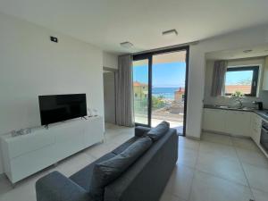 a living room with a couch and a flat screen tv at Mimì a Mare in Grottammare