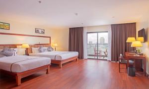 a hotel room with two beds and a balcony at Poulo Wai Hotel & Apartment in Phnom Penh
