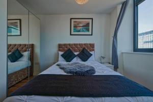 um quarto com uma cama grande e 2 janelas em Bright & Comfortable 2-Bedroom Central Flat with Parking em Liverpool