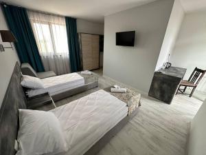a hotel room with two beds and a television at Studios and Apartments Pomorie in Pomorie