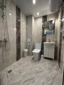 y baño con aseo, lavabo y ducha. en Studios and Apartments Pomorie en Pomorie