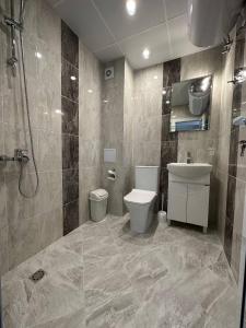a bathroom with a toilet and a sink and a shower at Studios and Apartments Pomorie in Pomorie