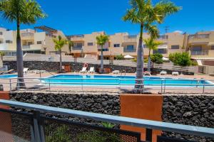 - une piscine avec des palmiers dans un complexe dans l'établissement Holiday Home with Private Pool by Dream Homes Tenerife, à Puerto de Santiago