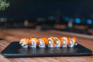 a row of sushi on a black plate on a table at Divino Caldera in Akrotiri