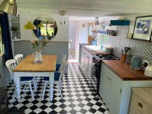 a kitchen with a table and a table and chairs at Olive's Cabin in Helston